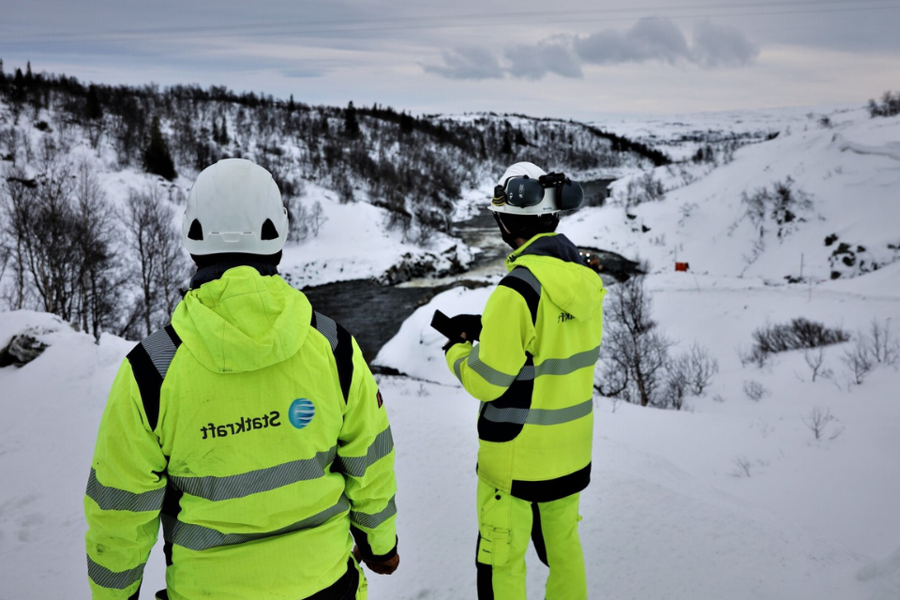 两位同事穿着安全装备站在nesjoø dam山顶上